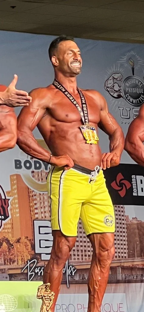 body builder on stage accepting award after receiving treatment from Dr. Zach Kaplan