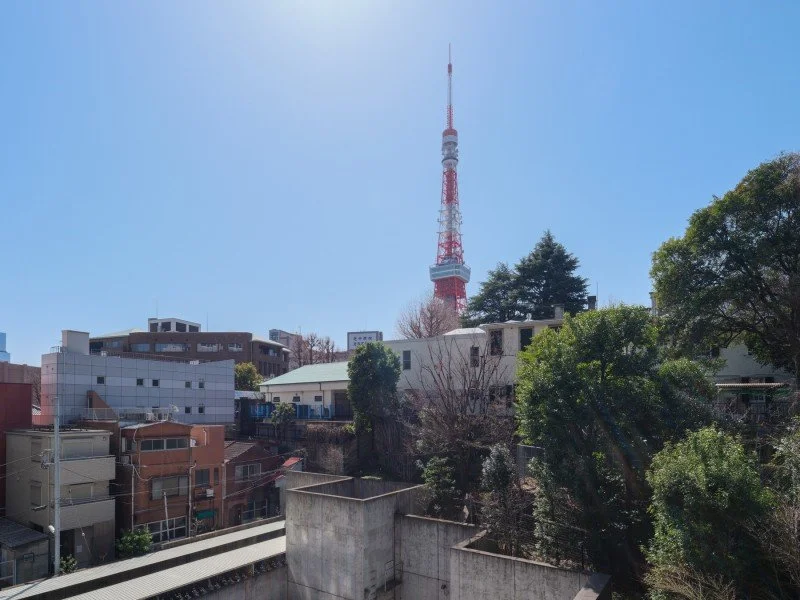 東京タワーが青空の中にそびえる都市の風景