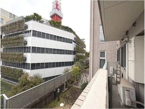 都心の高層ビルのバルコニーから見た隣の建物と空中にある通信塔