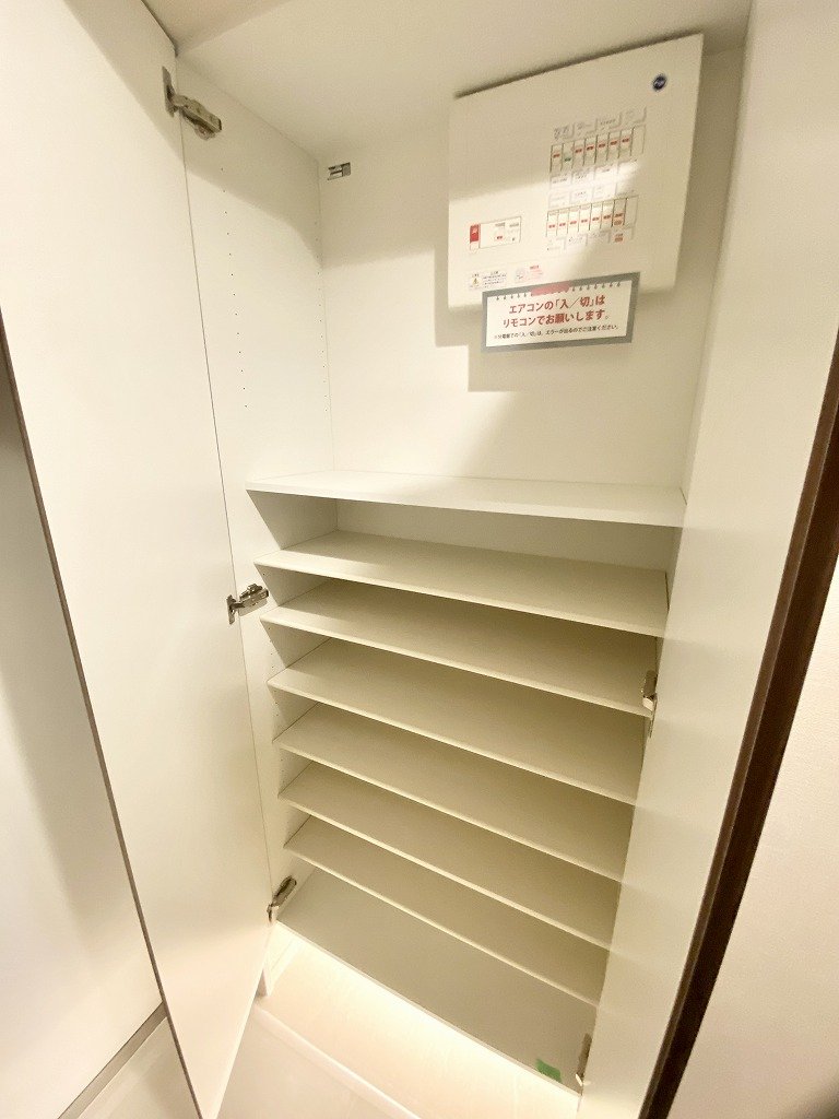 空の靴箱。複数の棚と電気メーターがある。