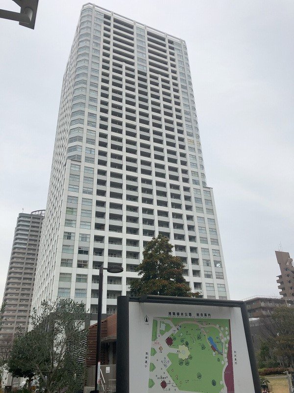 高層の白いビルと公園の案内図