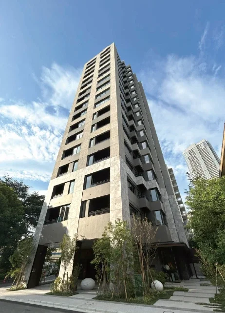 高層ビルと青空、周囲に木々がある都市の景観