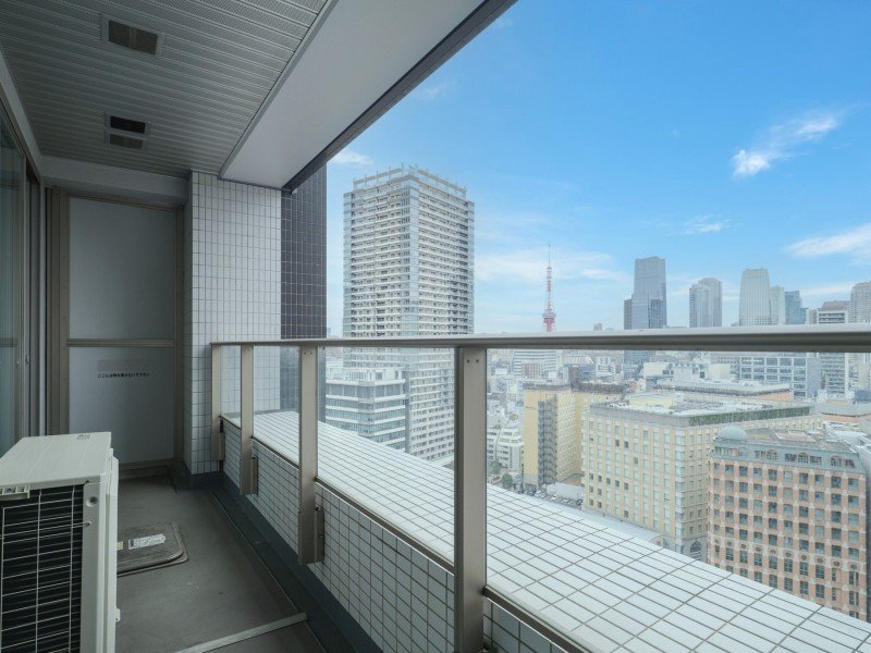 高層ビルの上層階からの都市の景色、青空と雲が見える