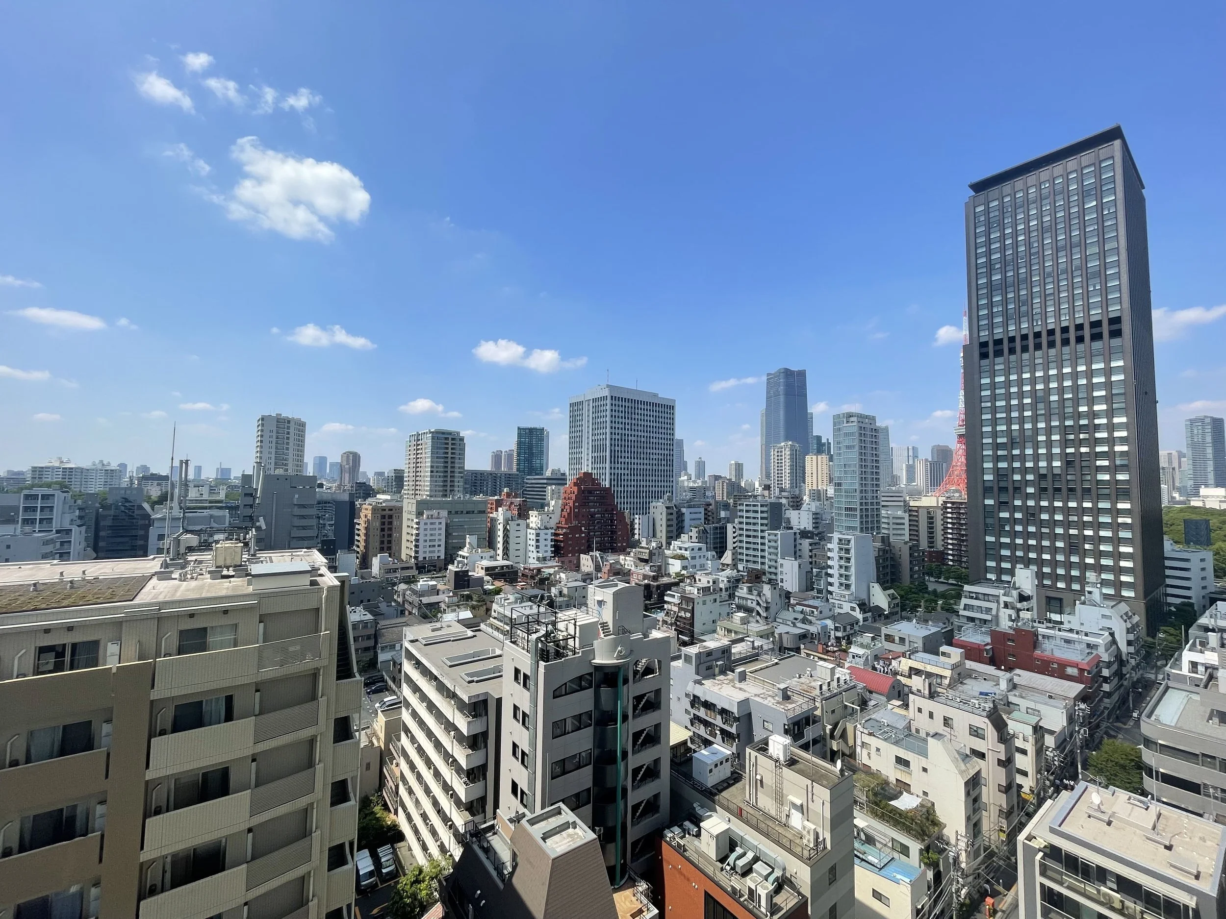 東京の高層ビルと都市の景色、青空と雲が見える
