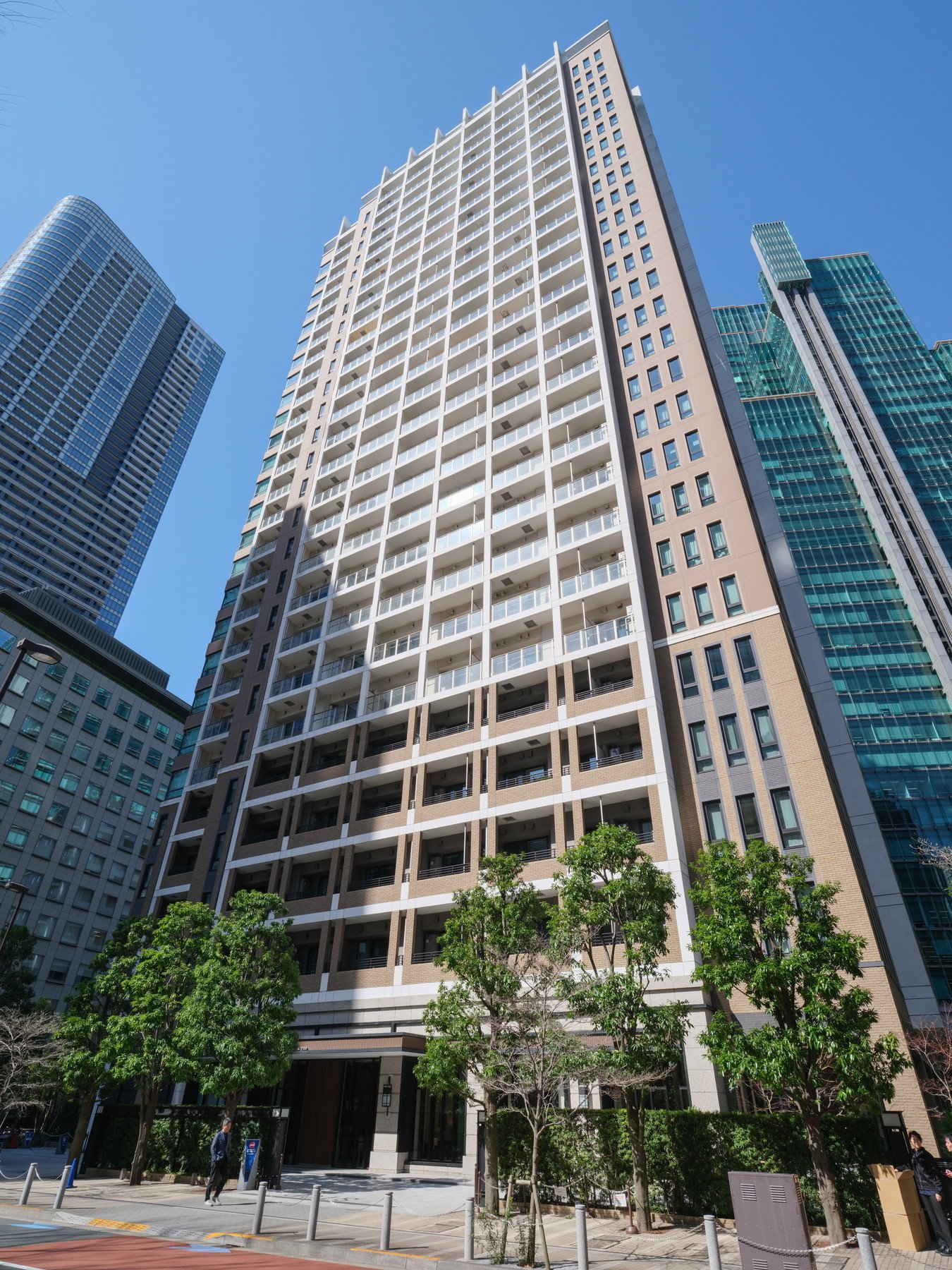 高層ビルが並ぶ都市の景色。青空とビルのガラス窓が見える。