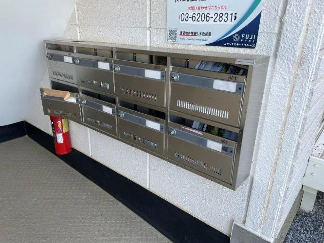 壁に設置された金属製の郵便受けと消火器
