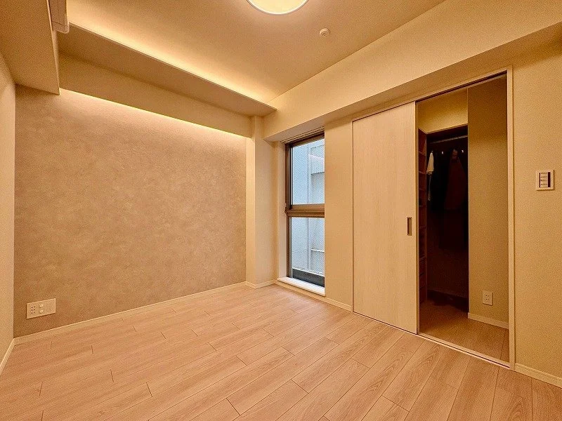 空の部屋、壁と床が明るい色調、窓とクローゼットのドアが見える