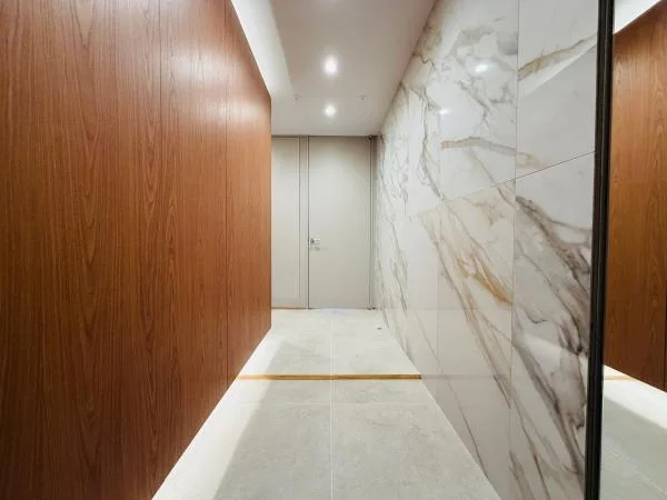 モダンな内装の廊下、木製の壁と大理石の壁、黄色いラインが床に走る