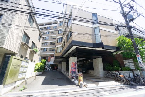 都市の建物と自転車、電柱と電線がある風景