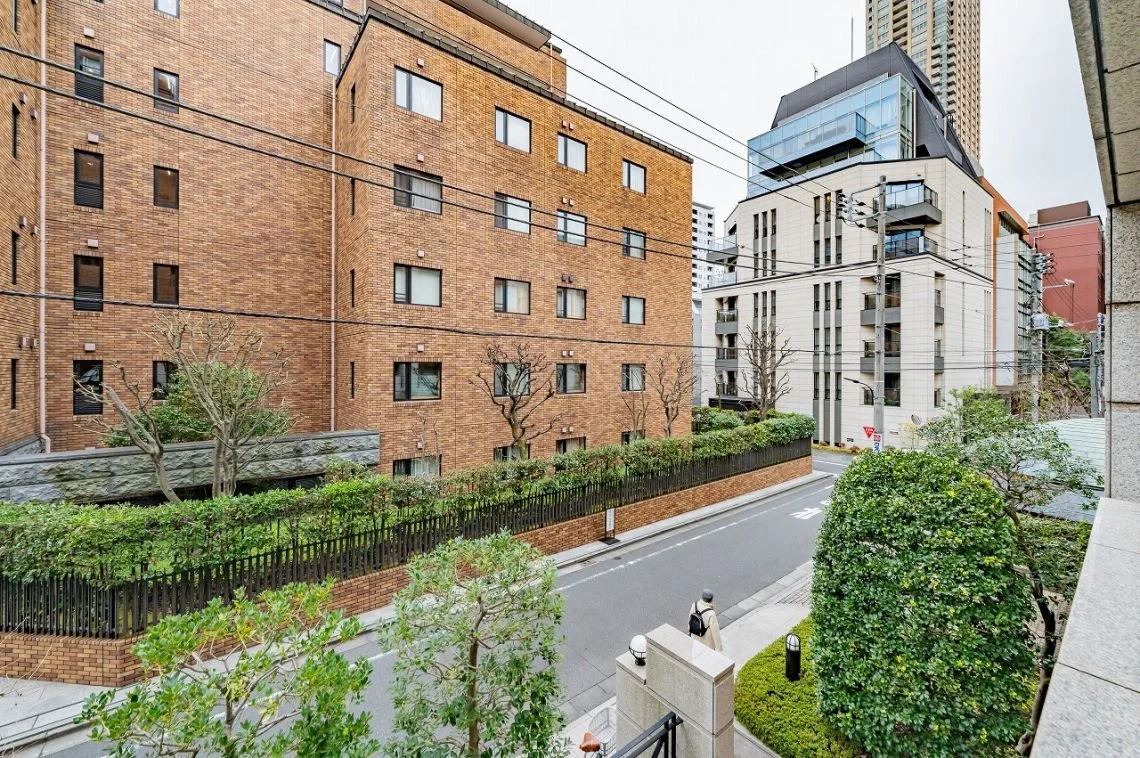 都市の街並み、レンガ造りの建物と道路、歩道に人がいる風景