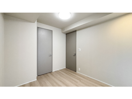 空の部屋、白い壁と木製の床、2つのドアと天井の照明