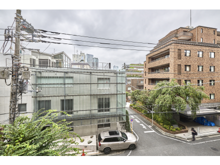 都市の通りと建物、車と人、電線が見える景色