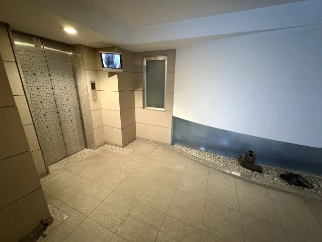 エレベーターの前のロビーの角に小さなテレビと窓があります。