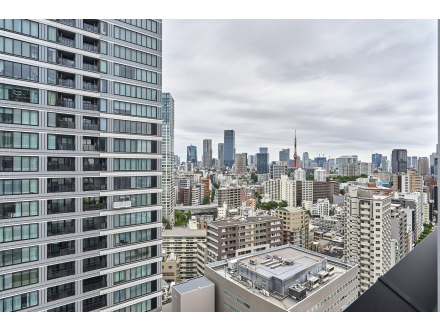 高層ビルの窓から見た都心の都市景観、空は曇り空