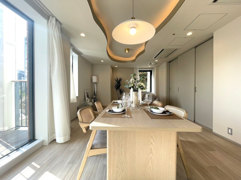 木製のダイニングテーブルに白い食器とグラスがセットされているシンプルでモダンなダイニングルームの内装