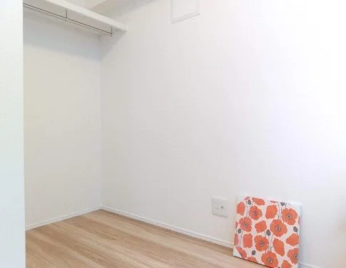 白い壁の部屋で、角に花柄の模様のパネルが置かれている。