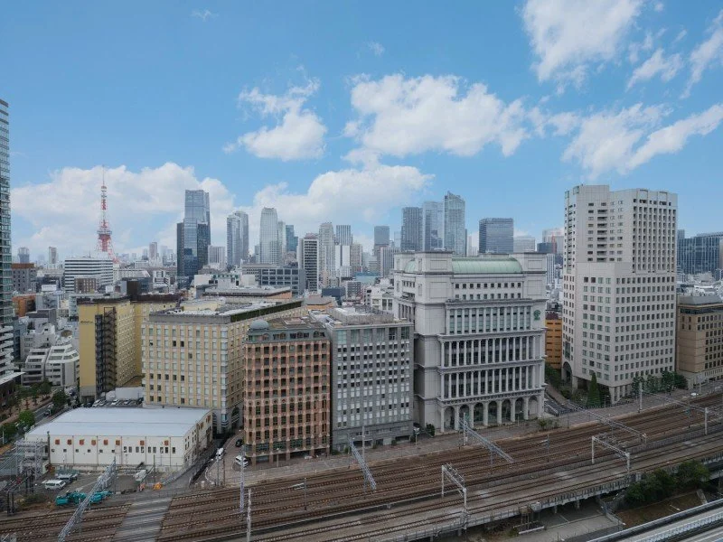 東京の都市街並みと高層ビル群、青空と白い雲が広がる景色