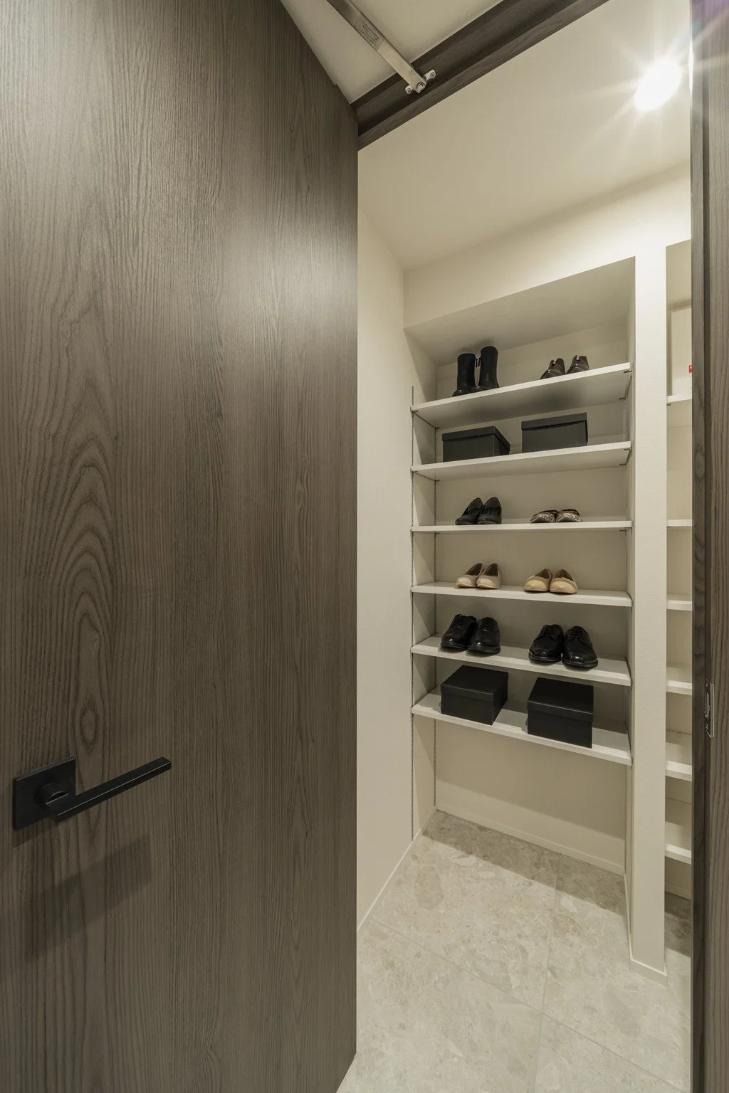 クローゼット内の靴収納棚に靴が整然と並べられている様子