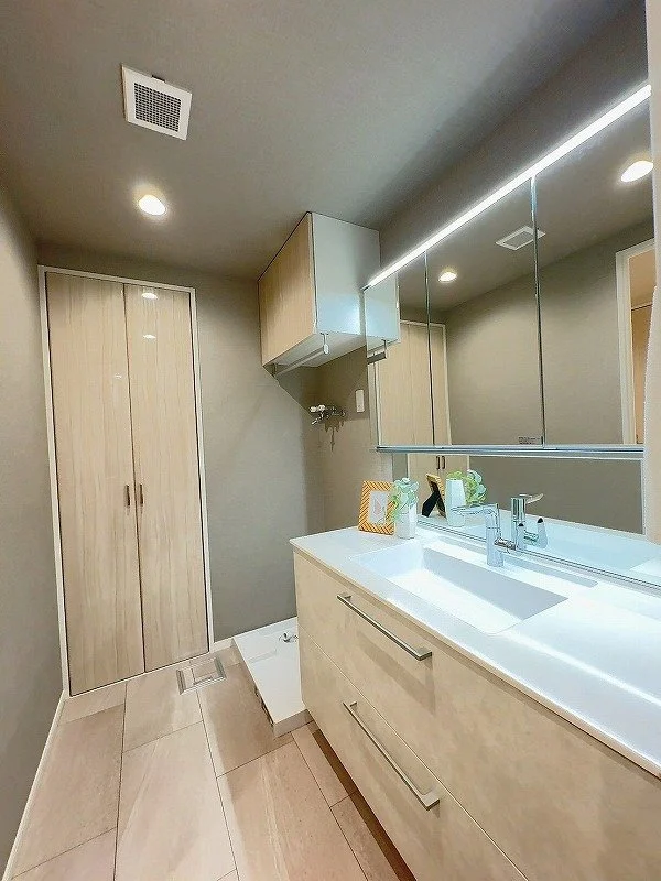 洗面台と鏡、収納棚がある清潔なバスルームの内部