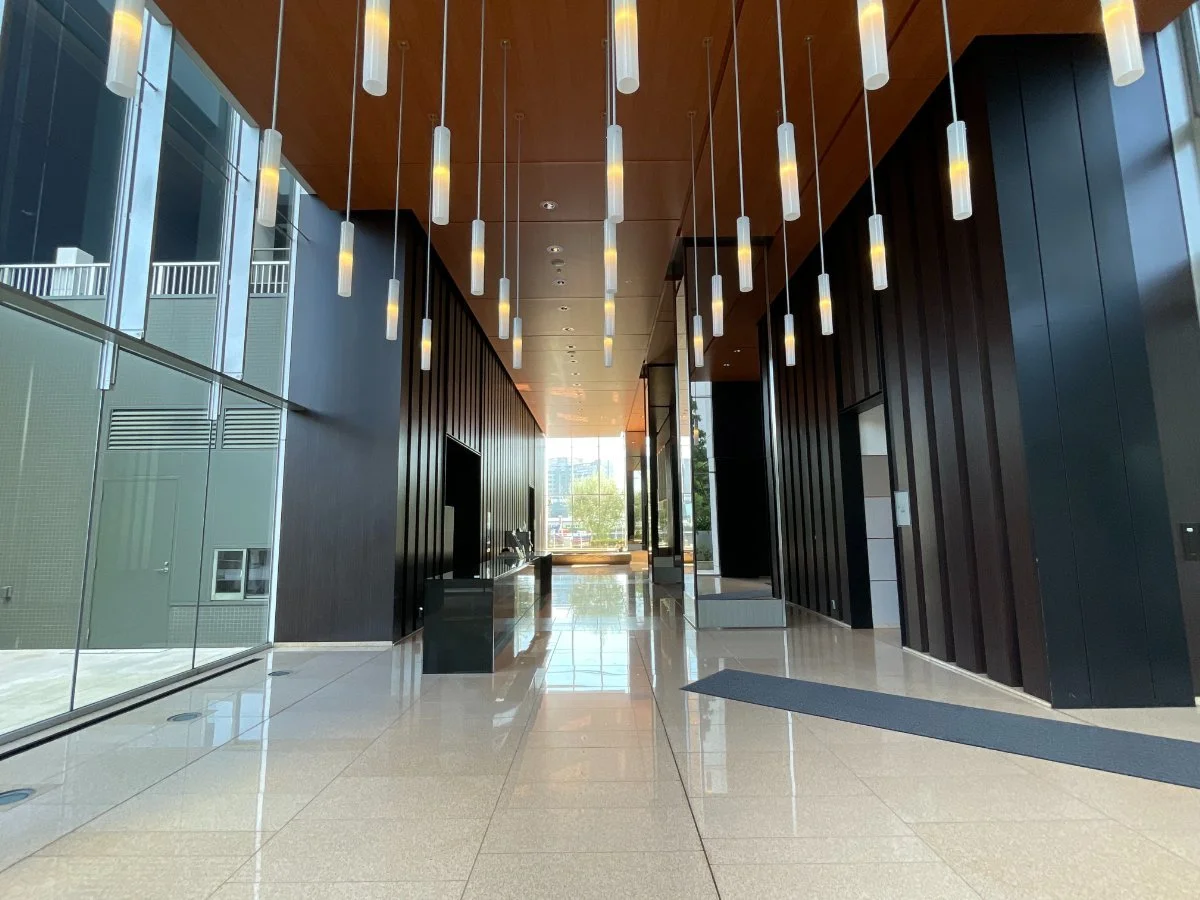 モダンな建築のロビー、天井のシャンデリアと大きな窓から自然光が差し込む