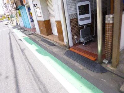 路肩の歩道と自動販売機のある店舗の前景