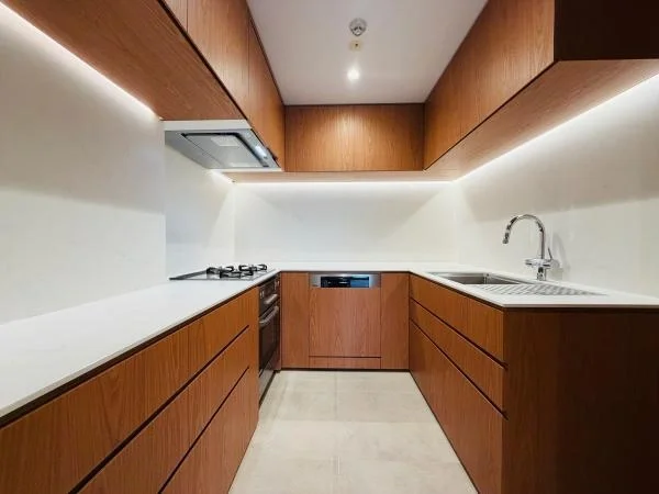 モダンなキッチン、木製キャビネットと白いカウンター、ガスコンロとシンク付きのデザイン