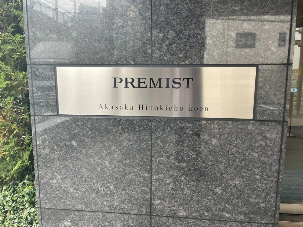 灰色の石の壁に金属の看板が設置され、