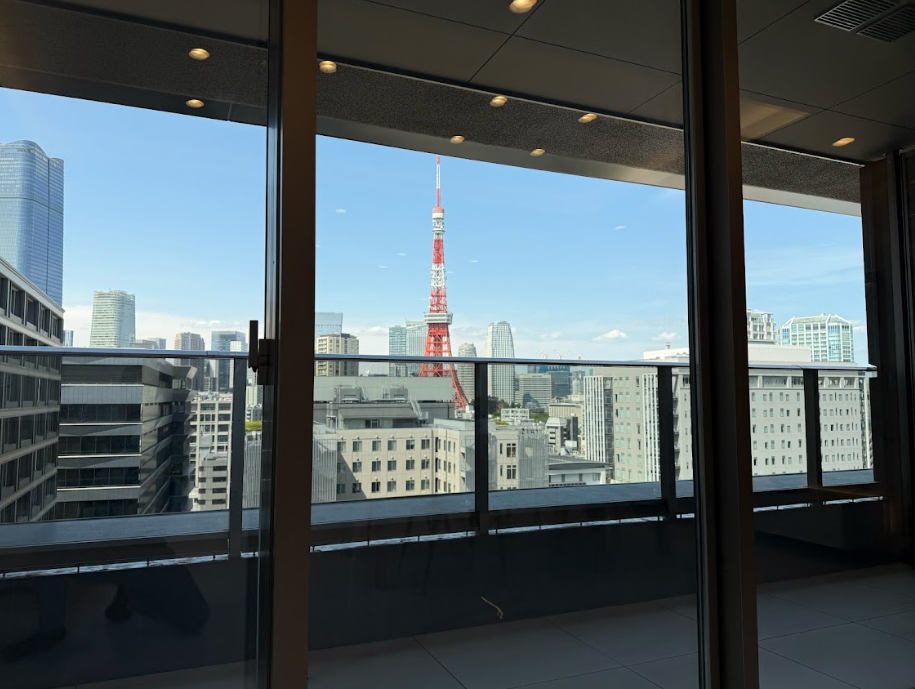 高層ビルの窓から東京タワーと都市の景色が見える風景