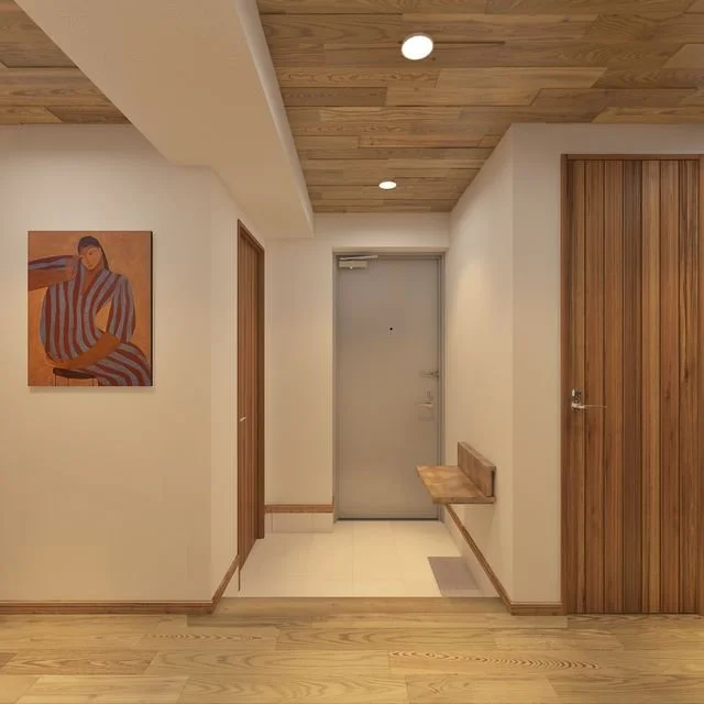 シンプルな玄関の内装、白い壁と木製の天井とドア、壁に掛けられたアート作品と小さなベンチがある