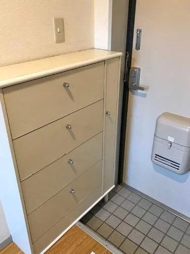 白い靴箱とドアの横にある壁付けの灰皿