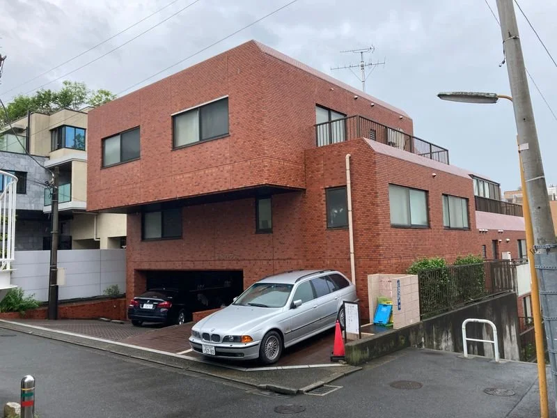 赤レンガの3階建て住宅と駐車場に車数台