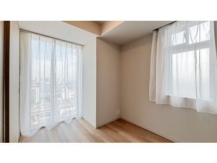 白いカーテンの窓から見える都市の景色