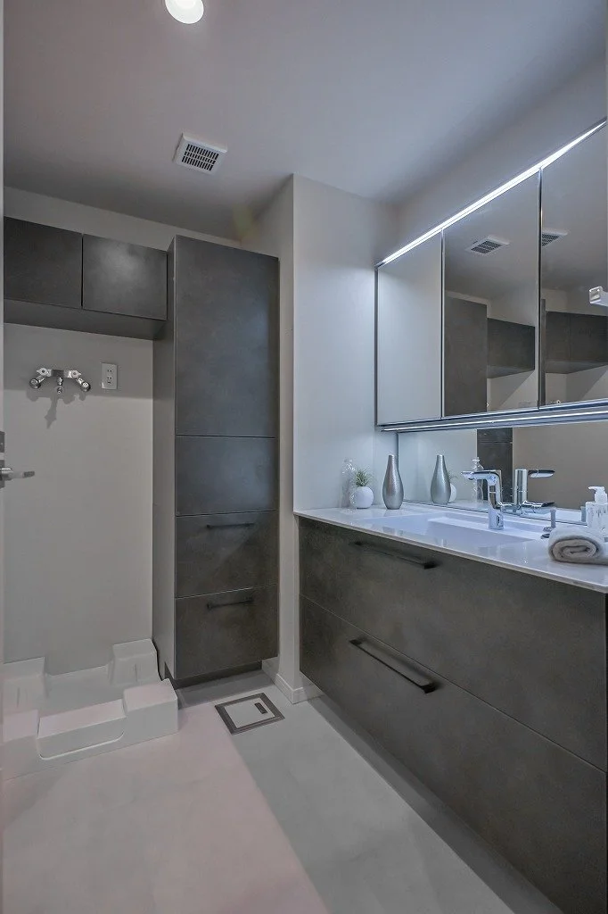 洗面台に鏡と装飾用の花瓶や器が置かれたモダンなバスルームの interior.