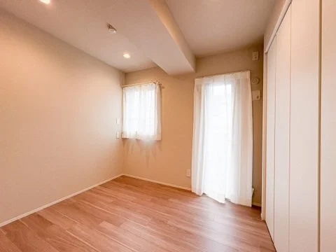空の部屋、木製の床と白い壁、窓にカーテンがついている