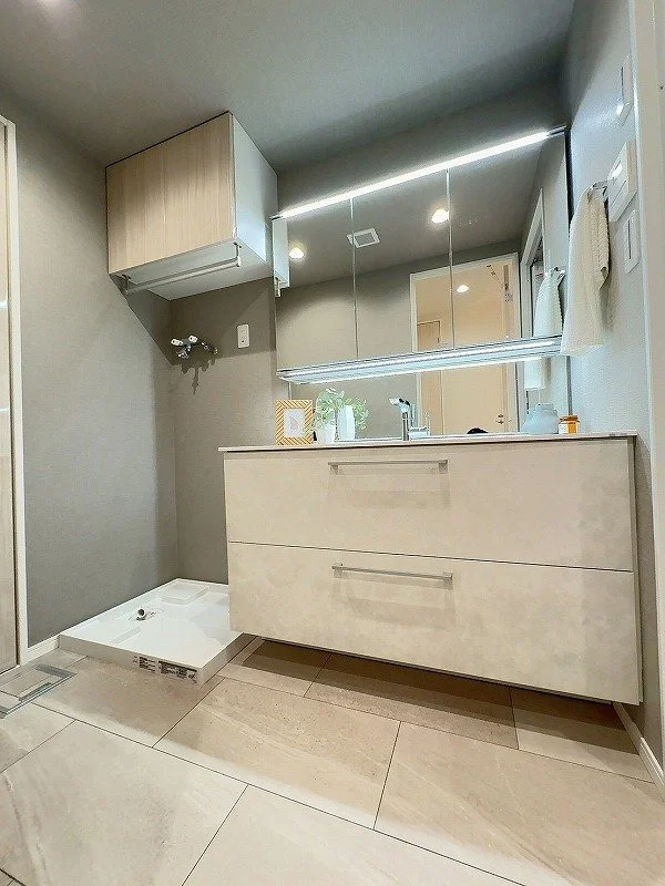 洗面所とミラーキャビネット、洗濯機スペースのあるシンプルなバスルーム