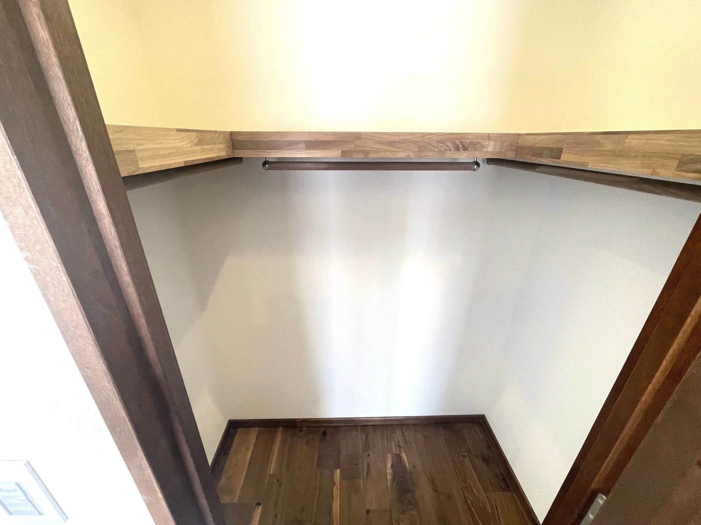 廊下とドア、木製の手すりとフローリングの床が見える写真