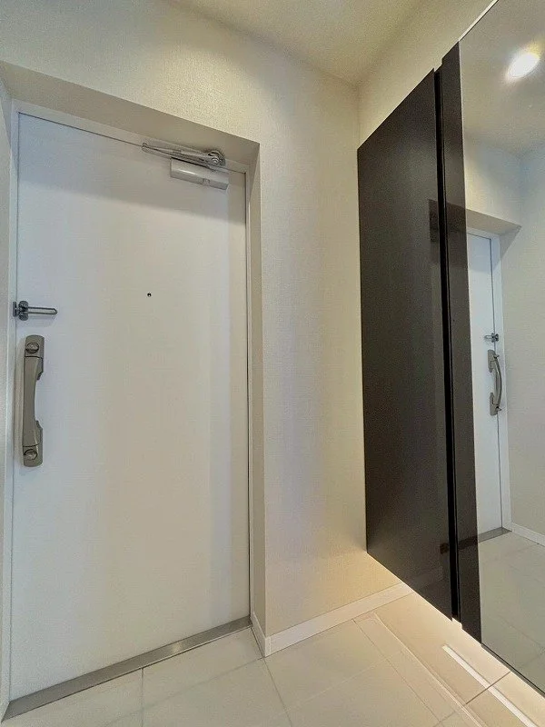 白いドアと黒い扉が並んでいる廊下の内側の風景