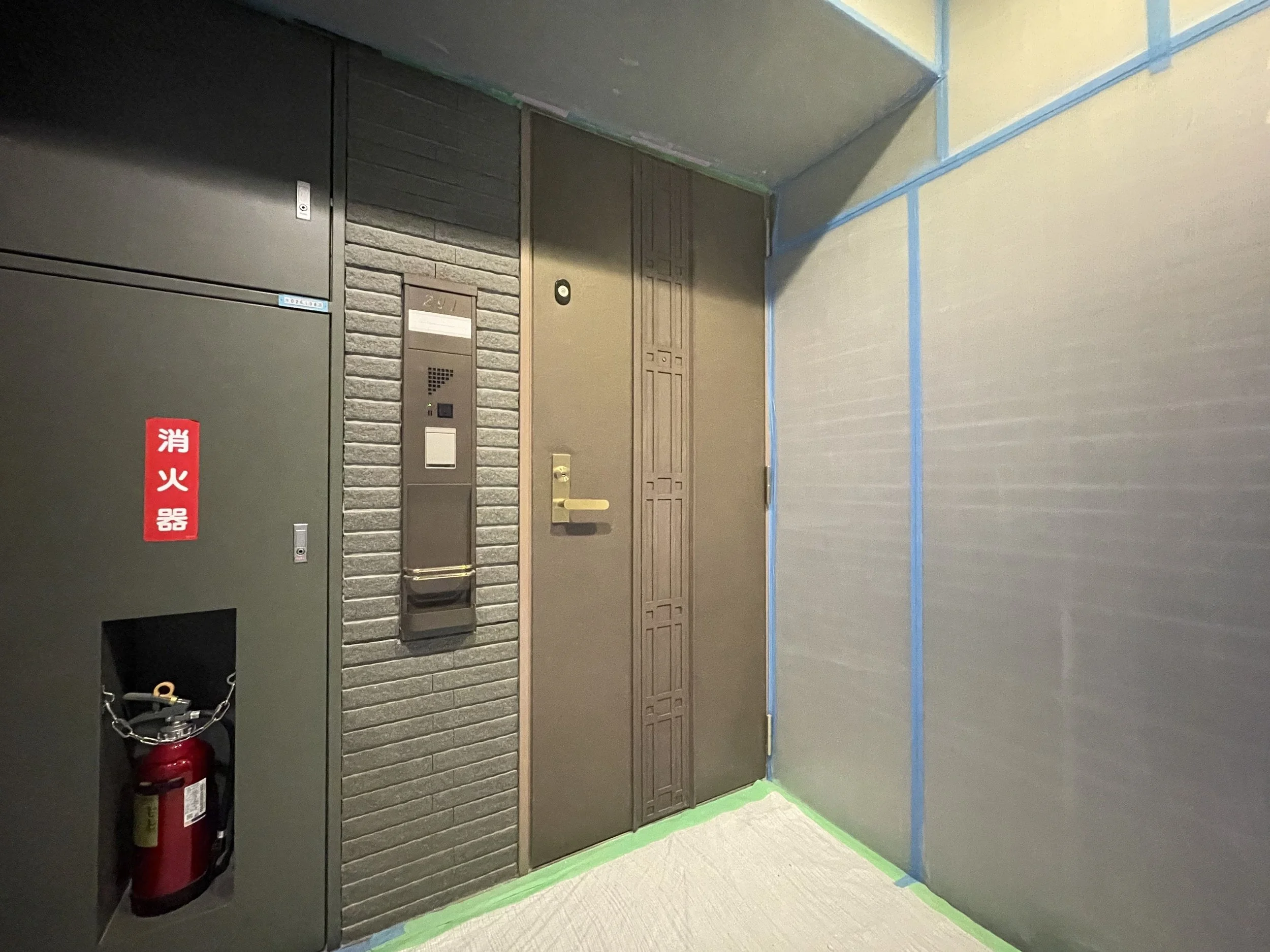 エレベーターボタンとインターホンのある入り口の壁、消火器