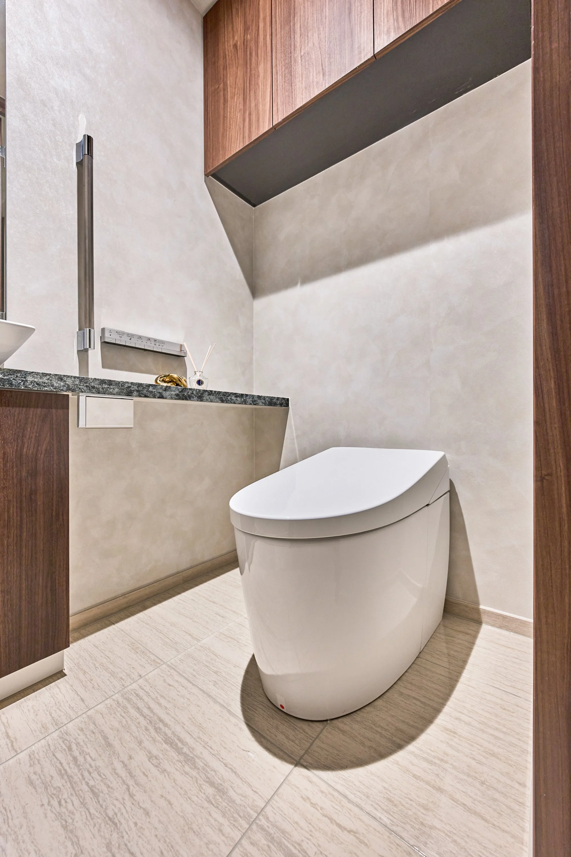 洋式トイレと洗面台のある現代的なトイレルームの interior, 木目の天井と壁, 大理石調の床と壁, シンプルで清潔感のあるデザイン