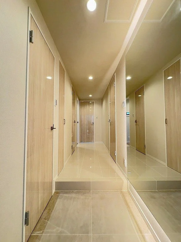 廊下の鏡に映る扉と天井の照明