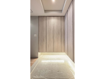 モダンなリビングのエントランス、木製のパネルと間接照明が特徴