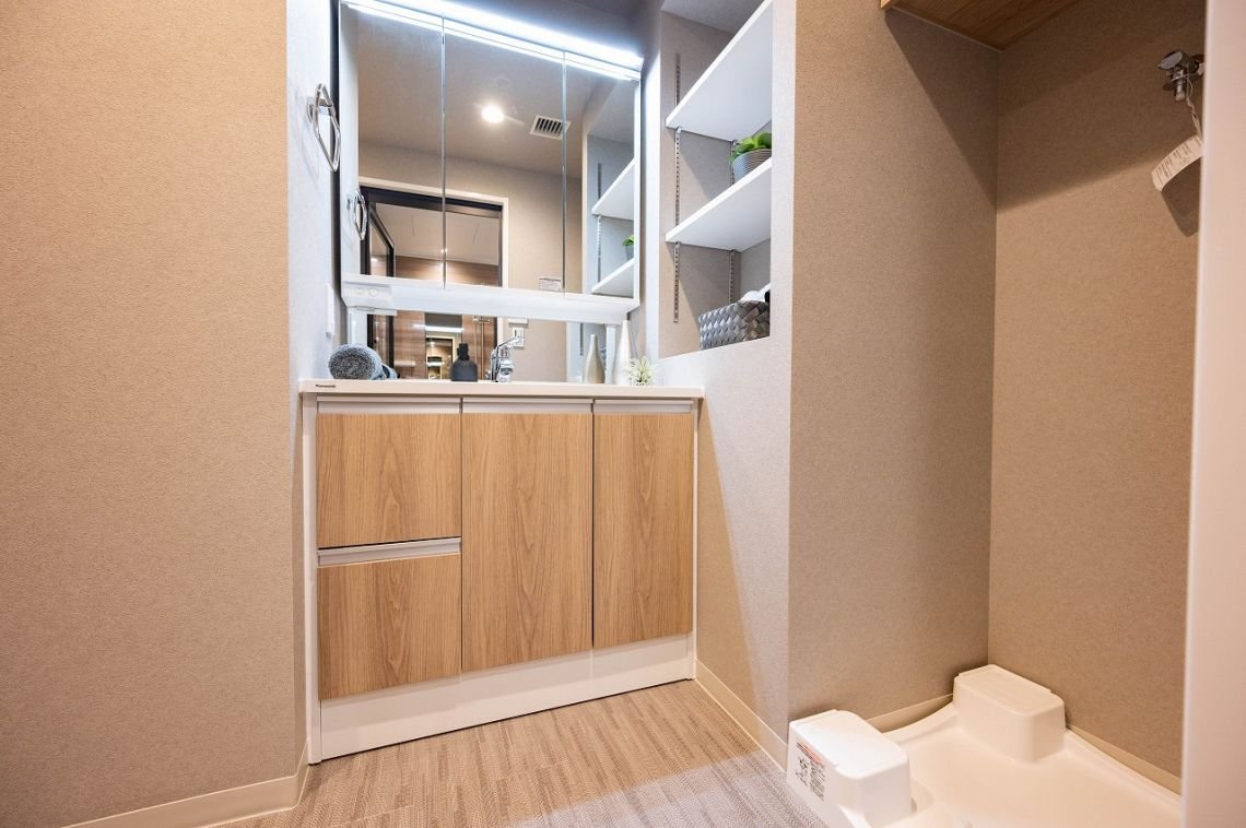洗面台と鏡、壁に棚と収納ボックスがある洗面所の interior 部屋