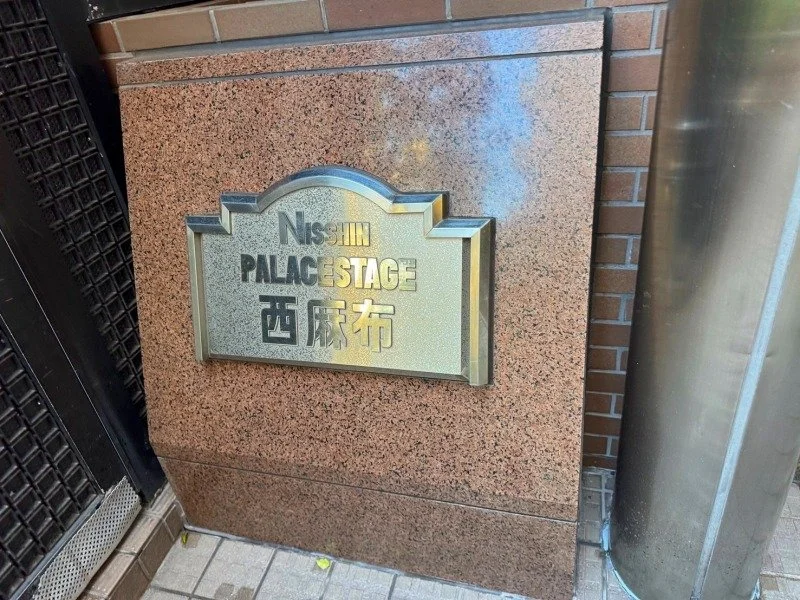 玄関脇の石の立て札に「西麻布 PALACE STAGE」と書かれている