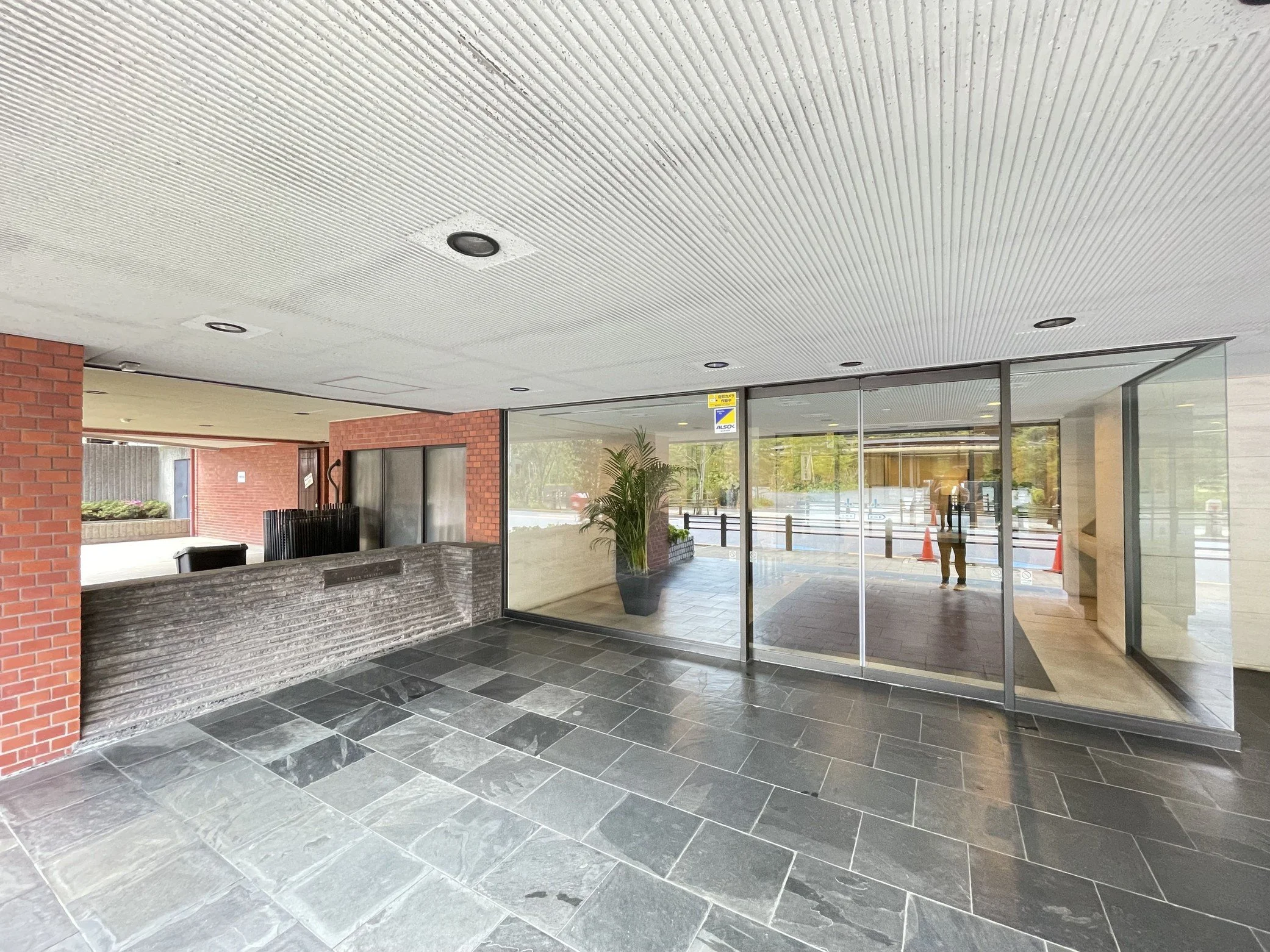 建物の出入り口付近の天井を見上げた写真。天井には点検用の照明が設置されている。