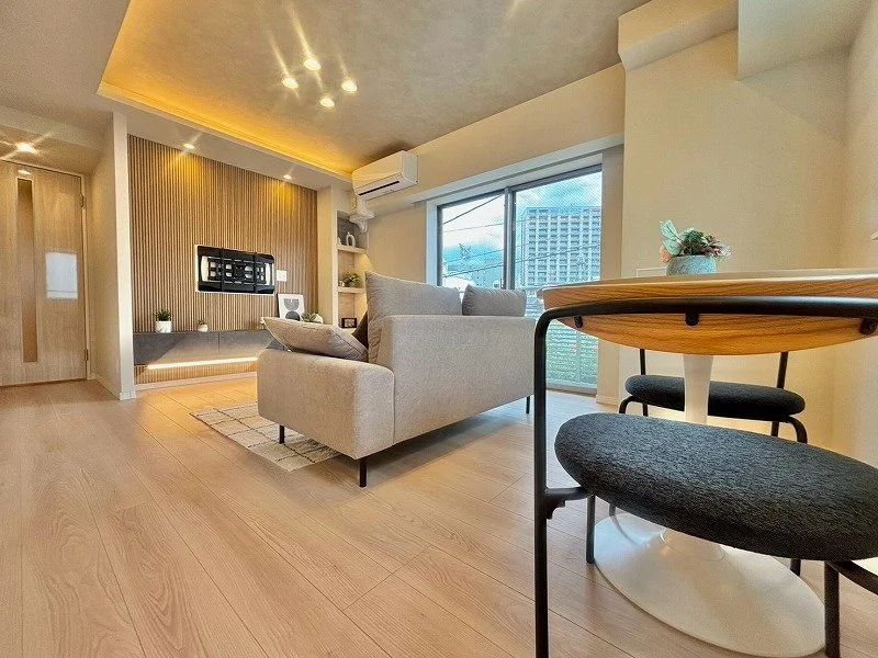 リビングルームの interior with ソファ、テーブル、窓からの景色、壁に装飾、明るい自然光が入る