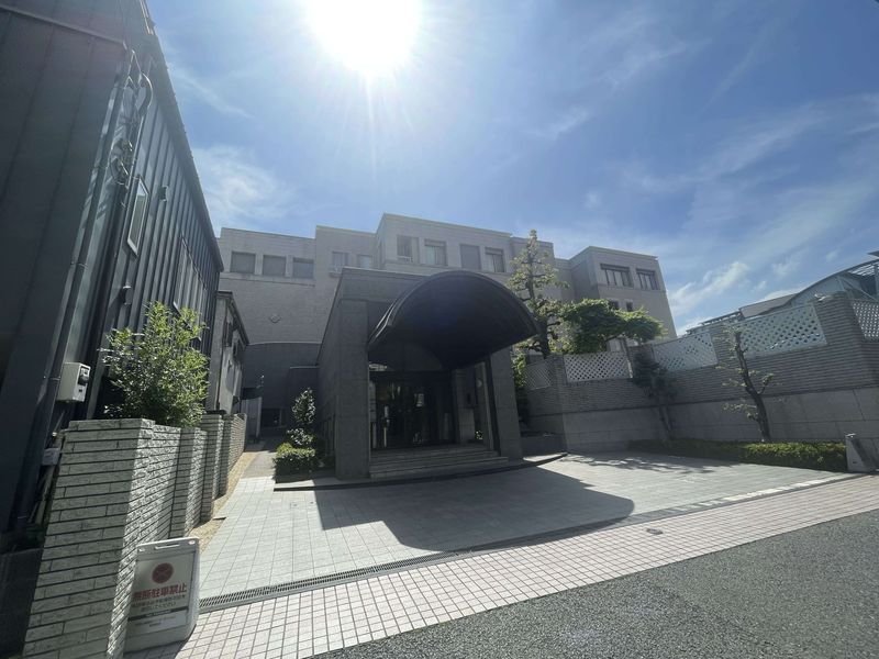 都市の建物の入口。日差しが強く、晴れた空。