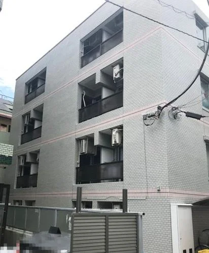四階建ての白いアパートメントの建物、窓とエアコンが設置されている