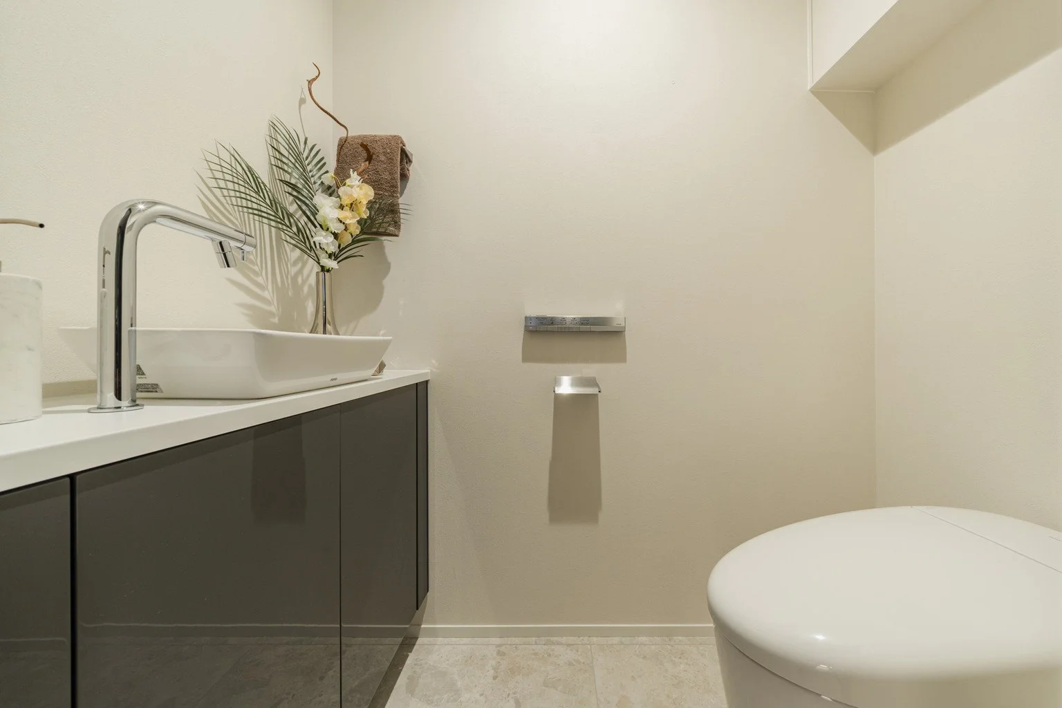 洗面台とトイレットペーパーホルダーがあるシンプルな浴室の interior