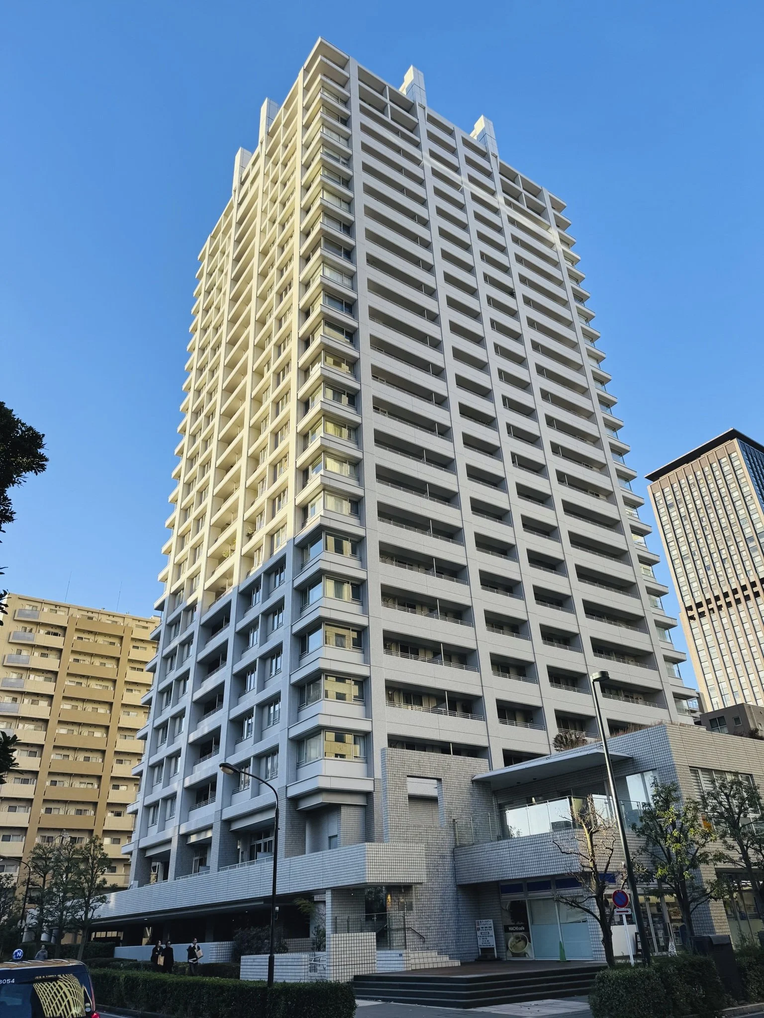 高層の白いマンションビルと青空