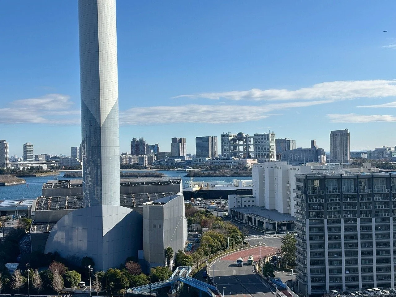 横浜の都市景観。ランドマークタワーが中央に見える。川と高層ビル群、そして青空が広がる光景です。